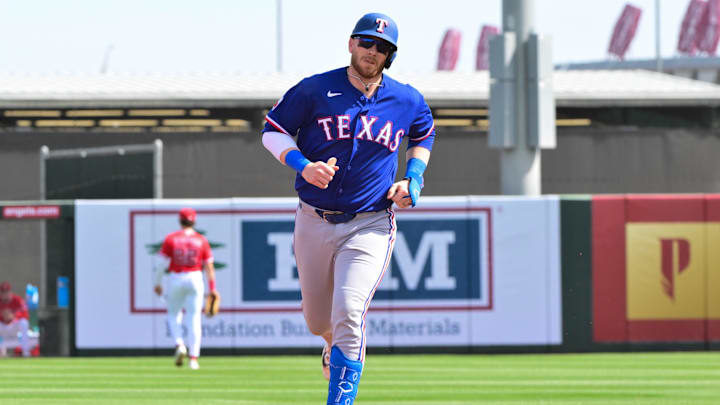 Feb 23, 2026; Tempe, Arizona, USA;  Texas Rangers catcher Danny Jansen (9) hits a two-run home run in the first inning against the Los Angeles Angels during a spring training game at Tempe Diablo Stadium. Mandatory Credit: Matt Kartozian-Imagn Images