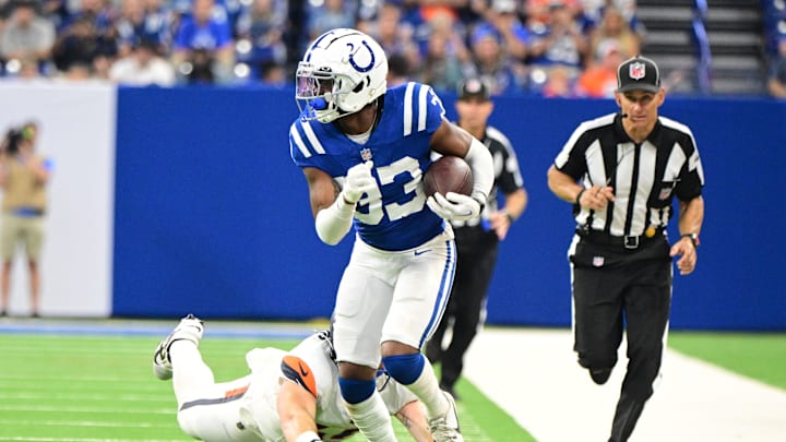 Aug 11, 2024; Indianapolis, Indiana, USA; Indianapolis Colts cornerback Micah Abraham (33) evades tackle by Denver Broncos tight end Nate Adkins (45) during the second half at Lucas Oil Stadium. Mandatory Credit: Marc Lebryk-Imagn Images