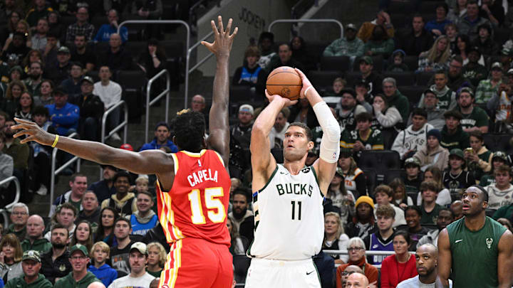 Oct 29, 2023; Milwaukee, Wisconsin, USA; Milwaukee Bucks center Brook Lopez (11) puts up a shot against Atlanta Hawks center Clint Capela (15) in the first quarter  at Fiserv Forum. Mandatory Credit: Michael McLoone-Imagn Images