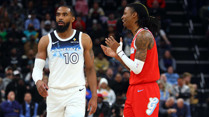 Jan 20, 2025; Memphis, Tennessee, USA; Memphis Grizzlies guard Ja Morant (12) reacts toward Minnesota Timberwolves guard Mike Conley (10) during the second half at FedExForum. Mandatory Credit: Petre Thomas-Imagn Images