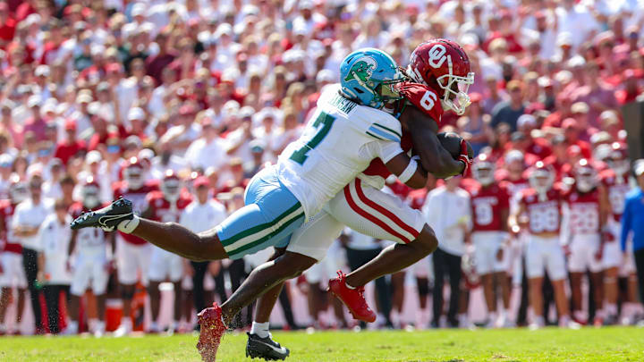 Sep 14, 2024; Norman, Oklahoma, USA;  Oklahoma Sooners wide receiver Deion Burks (6) runs with the ball as Tulane Green Wave safety Caleb Ransaw (7) defends during the first half at Gaylord Family-Oklahoma Memorial Stadium. Mandatory Credit: Kevin Jairaj-Imagn Images