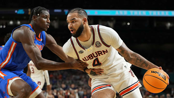 Apr 5, 2025; San Antonio, TX, USA; Auburn Tigers forward Johni Broome (4) drives to the basket against Florida Gators center Rueben Chinyelu (9) during the first half in the semifinals of the men's Final Four of the 2025 NCAA Tournament at the Alamodome. Mandatory Credit: Bob Donnan-Imagn Images