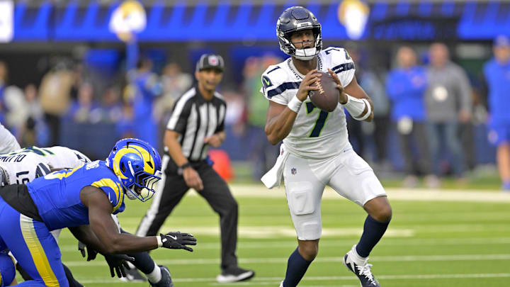 Jan 5, 2025; Inglewood, California, USA; Seattle Seahawks quarterback Geno Smith (7) scrambles away from Los Angeles Rams linebacker Byron Young (0) and throws for a touchdown in the first half at SoFi Stadium. Mandatory Credit: Jayne Kamin-Oncea-Imagn Images Jan 5, 2025; Inglewood, California, USA; Seattle Seahawks quarterback Geno Smith (7) scrambles away from Los Angeles Rams linebacker Byron Young (0) and throws for a touchdown in the first half at SoFi Stadium. Mandatory Credit: Jayne Kamin-Oncea-Imagn Images