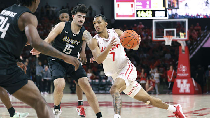 Nov 8, 2025; Houston, Texas, USA; Houston Cougars guard Milos Uzan (7) drives witht the ball as Towson Tigers guard Tyler Tejada (15) defends during the second half at Fertitta Center. Mandatory Credit: Troy Taormina-Imagn Images