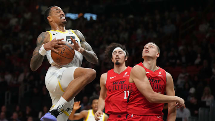 Jan 4, 2025; Miami, Florida, USA;  Utah Jazz forward John Collins (20) goes up for a layup as Miami Heat guard Jaime Jaquez Jr. (11) and forward Nikola Jovic (5) defend in the first half at Kaseya Center. Mandatory Credit: Jim Rassol-Imagn Images