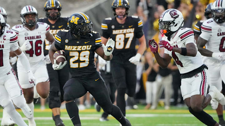 Sep 20, 2025; Columbia, Missouri, USA; Missouri Tigers running back Ahmad Hardy (29) runs the ball as South Carolina Gamecocks defensive back Vicari Swain (4) defends during the first half of the game at Faurot Field at Memorial Stadium. Mandatory Credit: Denny Medley-Imagn Images