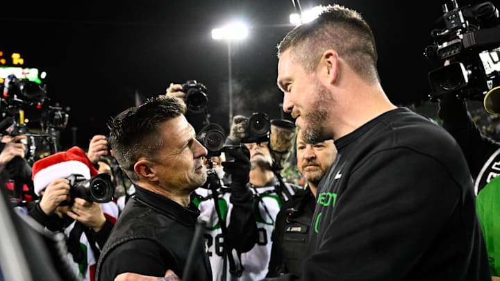 Dec 20, 2025; Eugene, OR, USA; James Madison Dukes head coach Bob Chesney and Oregon Ducks head coach Dan Lanning greet one another after the game at Autzen Stadium. Mandatory Credit: Troy Wayrynen-Imagn Images