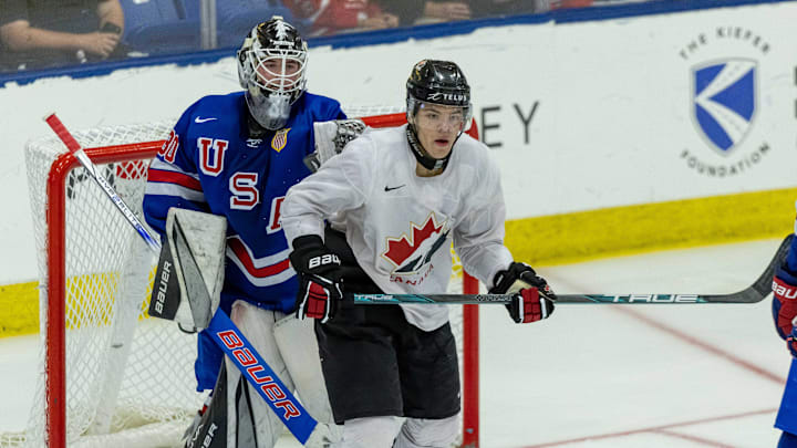 Aug 3, 2024; Plymouth, MI, USA; Canada's forward Tij Iginla (14) sets up in front of USA’s goaltender Hampton Slukynsky (30) during the second period of the 2024 World Junior Summer Showcase at USA Hockey Arena. Mandatory Credit: David Reginek-Imagn Images