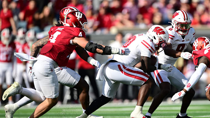 Nov 15, 2025; Bloomington, Indiana, USA;  Wisconsin Badgers running back Gideon Ituka (10) runs the ball past Indiana Hoosiers linebacker Aiden Fisher (4) during the second quarter at Memorial Stadium. Mandatory Credit: Marc Lebryk-Imagn Images