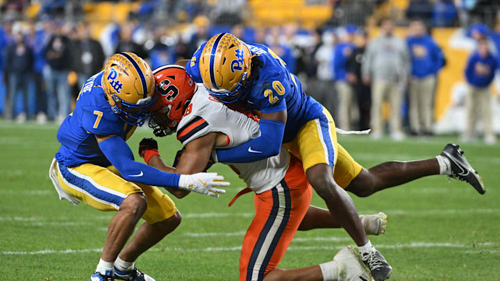 Oct 24, 2024; Pittsburgh, Pennsylvania, USA; Pittsburgh Panthers linebacker Jordan Bass (20) and defensive back Javon McIntyre (7) tackle Syracuse Orange wide receiver Emanuel Ross (18) during the second quarter at Acrisure Stadium. Mandatory Credit: Barry Reeger-Imagn Images