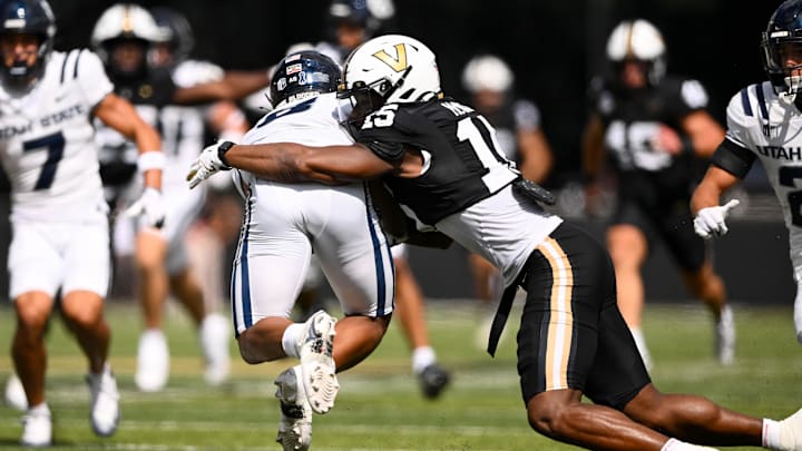 Sep 27, 2025; Nashville, Tennessee, USA; Vanderbilt Commodores defensive lineman Zaylin Wood (15) tackles Utah State Aggies running back Javen Jacobs (8) for a loss during the first half at FirstBank Stadium. Mandatory Credit: Steve Roberts-Imagn Images Sep 27, 2025; Nashville, Tennessee, USA; Vanderbilt Commodores defensive lineman Zaylin Wood (15) tackles Utah State Aggies running back Javen Jacobs (8) for a loss during the first half at FirstBank Stadium. Mandatory Credit: Steve Roberts-Imagn Images