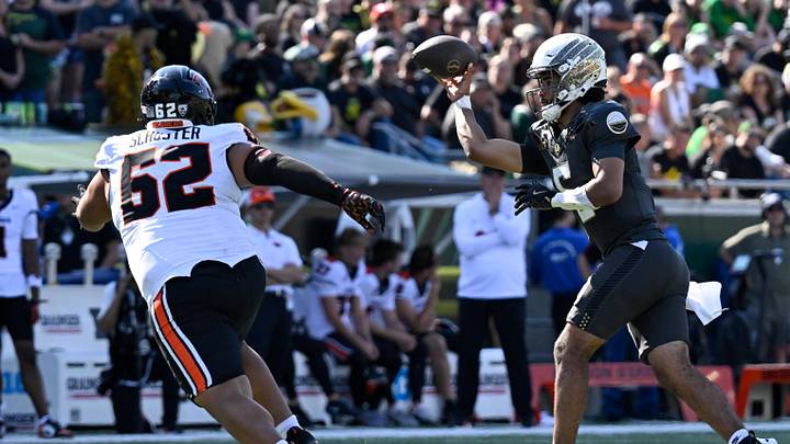 Sep 20, 2025; Eugene, Oregon, USA; Oregon Ducks quarterback Dante Moore (5) passes the ball defended by Oregon State Beavers defensive lineman Jacob Schuster (62) during the fourth quarter of the game at Autzen Stadium. Mandatory Credit: Troy Wayrynen-Imagn Images