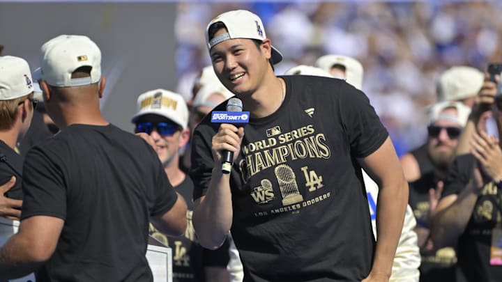 Nov 1, 2024; Los Angeles, CA, USA;  Los Angeles Dodgers manager Dave Roberts (30) introduces designated hitter Shohei Ohtani (17) to speak to fans during the World Series Championship Celebration at Dodger Stadium. Mandatory Credit: Jayne Kamin-Oncea-Imagn Images
