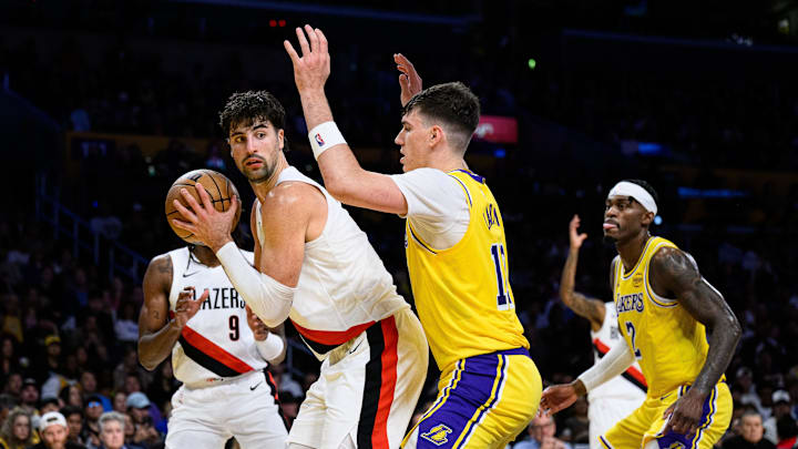 Oct 27, 2025; Los Angeles, California, USA; Portland Trail Blazers forward Deni Avdija (8) looks to pass while under pressure from Los Angeles Lakers forward Jake LaRavia (12) during the first half at Crypto.com Arena. Mandatory Credit: William Liang-Imagn Images