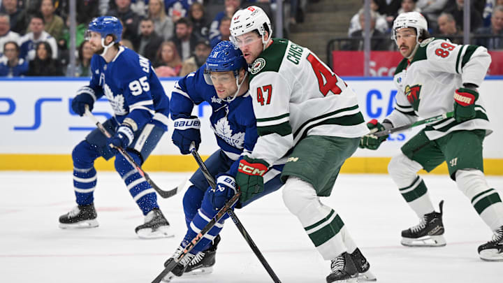 Jan 29, 2025; Toronto, Ontario, CAN;  Minnesota Wild defenseman Declan Chisholm (47) covers Toronto Maple Leafs forward Max Domi (11) in the first period at Scotiabank Arena. Mandatory Credit: Dan Hamilton-Imagn Images