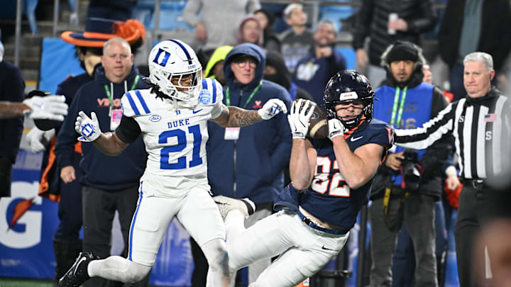 Dec 6, 2025; Charlotte, NC, USA; Virginia Cavaliers wide receiver Eli Wood (82) scores a touchdown to tie the score near the end of the 4th quarter as Duke Blue Devils cornerback Landan Callahan (21) defends during the ACC Championship game at Bank of America Stadium. Mandatory Credit: Bob Donnan-Imagn Images
