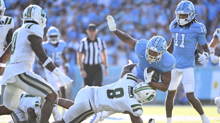 Sep 7, 2024; Chapel Hill, North Carolina, USA; North Carolina Tar Heels running back Caleb Hood (4) is tackled by Charlotte 49ers linebacker Cam Burden (8) in the third quarter at Kenan Memorial Stadium. 