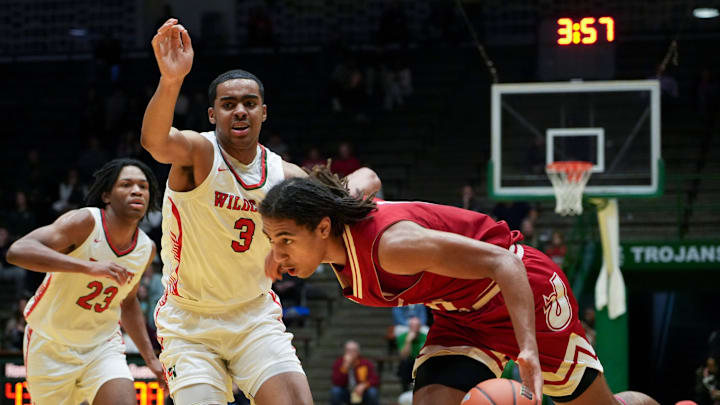 Jeffersonville Red Devils Tre Singleton (0) drives the lane as Lawrence North Wildcats Brennan Miller (3) defends, Saturday, March 16, 2024, during the IHSAA Class 4A semistate game at New Castle High School in Newcastle, Indiana. The Jeffersonville Red Devils defeated the Lawrence North Wildcats, 62-60.