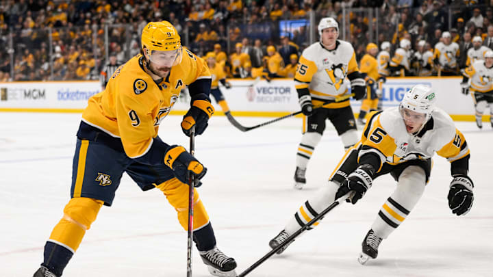Dec 19, 2024; Nashville, Tennessee, USA;  Nashville Predators left wing Filip Forsberg (9) takes a shot on goal against the Pittsburgh Penguins during the first period at Bridgestone Arena. Mandatory Credit: Steve Roberts-Imagn Images