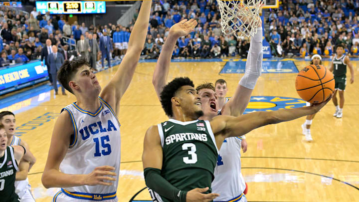 Michigan State Spartans guard Jaden Akins drives on the defense of UCLA Bruins Aday Mara and forward Tyler Bilodeau. Mandatory Credit: Jayne Kamin-Oncea-Imagn Images