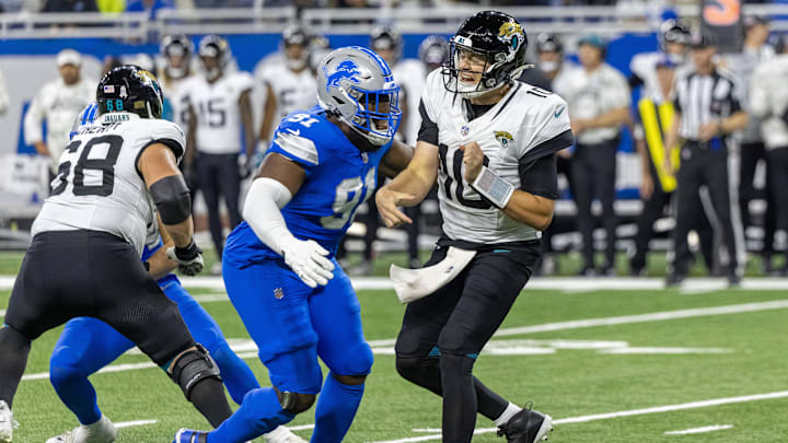 Nov 17, 2024; Detroit, Michigan, USA; Jacksonville Jaguars quarterback Mac Jones (10) passes the ball and is pressured by Detroit Lions defensive end Levi Onwuzurike (91) during the second half at Ford Field.
