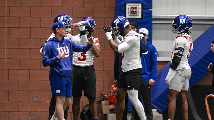 May 21, 2026; East Rutherford, NJ, USA; New York Giants linebacker Brian Burns (0) and outside linebackers coach Charlie Bullen react during organized team activities at Quest Diagnostics Training Center.  