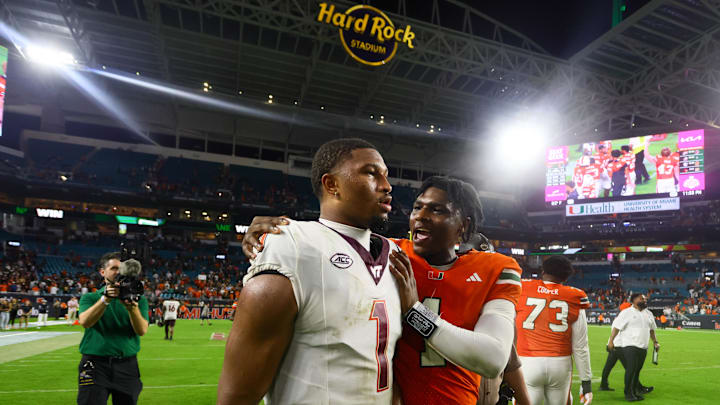 Sep 27, 2024; Miami Gardens, Florida, USA; Miami Hurricanes quarterback Cam Ward (1) and Virginia Tech Hokies quarterback Kyron Drones (1) talk on the field after the game at Hard Rock Stadium. Mandatory Credit: Sam Navarro-Imagn Images