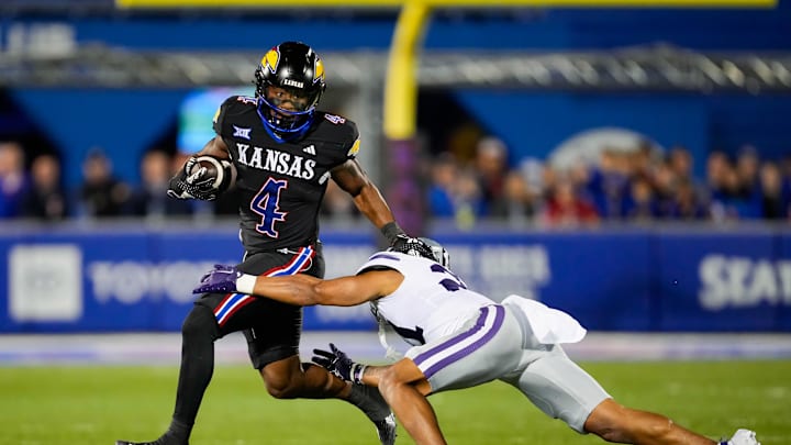 Nov 18, 2023; Lawrence, Kansas, USA; Kansas Jayhawks running back Devin Neal (4) runs the ball against Kansas State Wildcats safety Marques Sigle (21) during the first half at David Booth Kansas Memorial Stadium. Mandatory Credit: Jay Biggerstaff-Imagn Images Nov 18, 2023; Lawrence, Kansas, USA; Kansas Jayhawks running back Devin Neal (4) runs the ball against Kansas State Wildcats safety Marques Sigle (21) during the first half at David Booth Kansas Memorial Stadium. Mandatory Credit: Jay Biggerstaff-Imagn Images