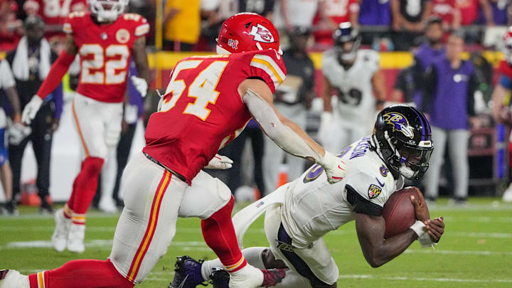 Baltimore Ravens quarterback Lamar Jackson runs the ball as Kansas City Chiefs linebacker Leo Chenal. Mandatory Credit: Denny Medley-Imagn Images