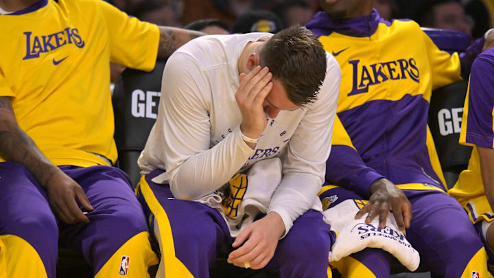 Mar 19, 2025; Los Angeles, California, USA;  Los Angeles Lakers guard Luka Doncic (77) holds his face on the bench after getting fouled against the Denver Nuggets at Crypto.com Arena. Mandatory Credit: Jayne Kamin-Oncea-Imagn Images