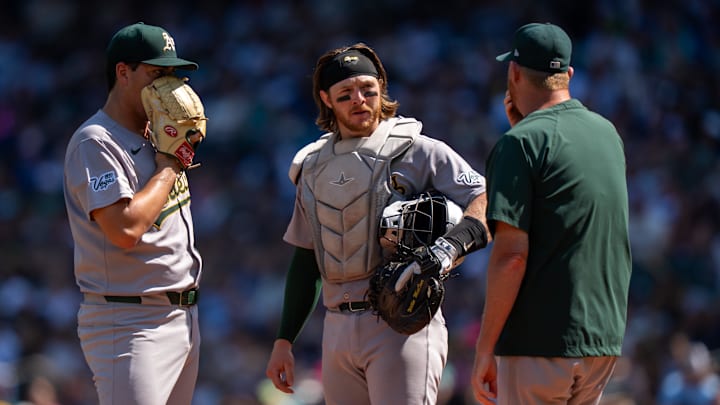 Aug 24, 2025; Seattle, Washington, USA; Athletics Athletics starting pitcher Jacob Lopez (57), left, catcher Willie MacIver (65), center, and pitching coach Scott Emerson meet at the mound during the second inning against the Seattle Mariners at T-Mobile Park. Mandatory Credit: Stephen Brashear-Imagn Images Aug 24, 2025; Seattle, Washington, USA; Athletics Athletics starting pitcher Jacob Lopez (57), left, catcher Willie MacIver (65), center, and pitching coach Scott Emerson meet at the mound during the second inning against the Seattle Mariners at T-Mobile Park. Mandatory Credit: Stephen Brashear-Imagn Images