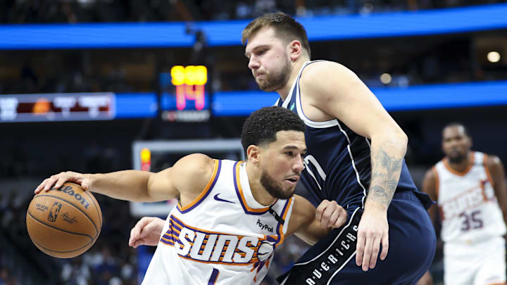Nov 8, 2024; Dallas, Texas, USA; Phoenix Suns guard Devin Booker (1) drives to the basket as Dallas Mavericks guard Luka Doncic (77) defends during the third quarter at American Airlines Center. Mandatory Credit: Kevin Jairaj-Imagn Images