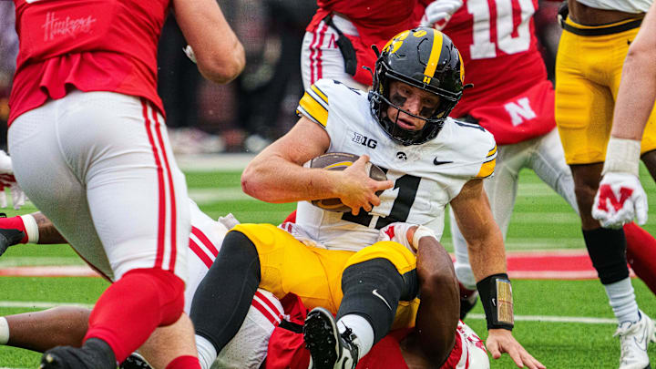 Nov 28, 2025; Lincoln, Nebraska, USA; Iowa Hawkeyes quarterback Mark Gronowski (11) is tackled by Nebraska Cornhuskers defensive lineman Riley van Poppel (5) during the third quarter at Memorial Stadium. Mandatory Credit: Dylan Widger-Imagn Images