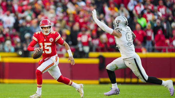 Nov 29, 2024; Kansas City, Missouri, USA; Kansas City Chiefs quarterback Patrick Mahomes (15) scrambles against Las Vegas Raiders defensive end Maxx Crosby (98) during the first half at GEHA Field at Arrowhead Stadium. Mandatory Credit: Jay Biggerstaff-Imagn Images