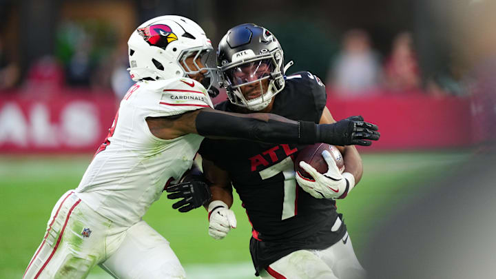Dec 21, 2025; Glendale, Arizona, USA;  Atlanta Falcons running back Bijan Robinson (7) takes a hit from Arizona Cardinals safety Budda Baker (3) during the second half at State Farm Stadium. Mandatory Credit: Joe Camporeale-Imagn Images