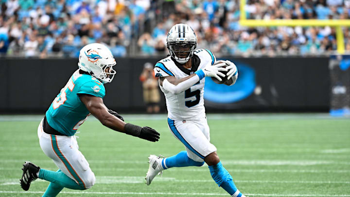 Oct 5, 2025; Charlotte, North Carolina, USA; Carolina Panthers running back Rico Dowdle (5) with the ball as Miami Dolphins linebacker Tyrel Dodson (25) defends in the second quarter at Bank of America Stadium. Mandatory Credit: Bob Donnan-Imagn Images