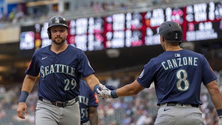 Seattle Mariners catcher Cal Raleigh (29) shakes hands with right fielder Dominic Canzone (8) after scoring a run against the Minnesota Twins in the third inning at Target Field on June 24. 