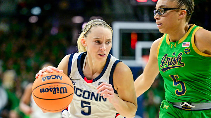 Dec 12, 2024; South Bend, Indiana, USA; Connecticut Huskies guard Paige Bueckers (5) dribbles as Notre Dame Fighting Irish guard Olivia Miles (5) defends in the first half at the Purcell Pavilion. Mandatory Credit: Matt Cashore-Imagn Images Dec 12, 2024; South Bend, Indiana, USA; Connecticut Huskies guard Paige Bueckers (5) dribbles as Notre Dame Fighting Irish guard Olivia Miles (5) defends in the first half at the Purcell Pavilion. Mandatory Credit: Matt Cashore-Imagn Images