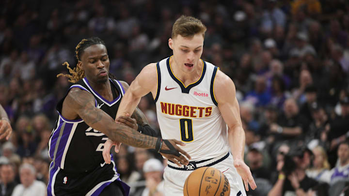 Apr 9, 2025; Sacramento, California, USA; Sacramento Kings guard Keon Ellis (23) attempts to steal the ball from Denver Nuggets guard Christian Braun (0) during the first quarter at Golden 1 Center. Mandatory Credit: Ed Szczepanski-Imagn Images
