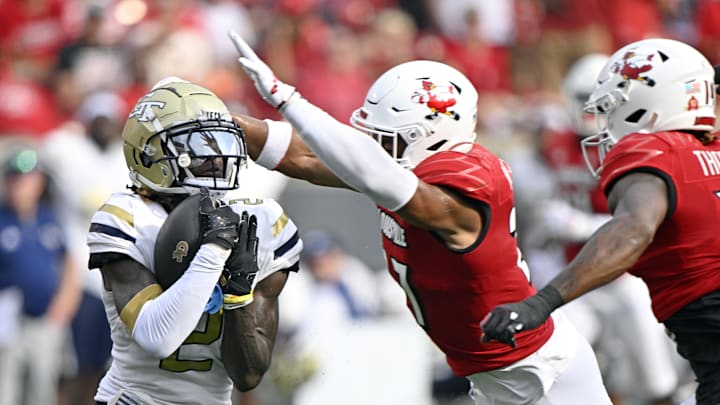 Sep 21, 2024; Louisville, Kentucky, USA;  Georgia Tech Yellow Jackets wide receiver Eric Singleton Jr. (2) catches a pass under the pressure of Louisville Cardinals defensive back Devin Neal (27) during the first half at L&N Federal Credit Union Stadium. Mandatory Credit: Jamie Rhodes-Imagn Images