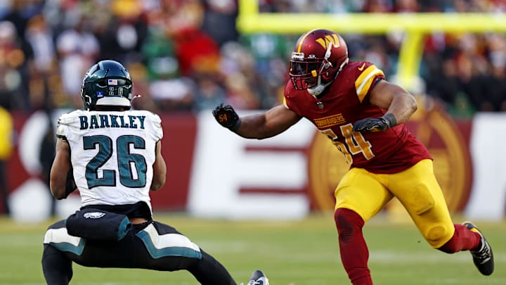 Dec 22, 2024; Landover, Maryland, USA; Philadelphia Eagles running back Saquon Barkley (26) drops a pass against Washington Commanders linebacker Bobby Wagner (54) during the fourth quarter at Northwest Stadium. Mandatory Credit: Peter Casey-Imagn Images