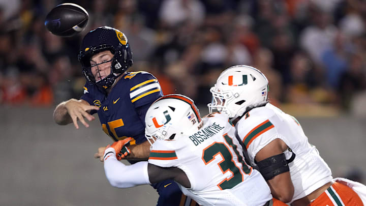 Oct 5, 2024; Berkeley, California, USA; Miami Hurricanes linebacker Wesley Bissainthe (31) and defensive back Jaden Harris (right) force an incomplete pass by California Golden Bears quarterback Fernando Mendoza (left) during the third quarter at California Memorial Stadium. Mandatory Credit: Darren Yamashita-Imagn Images