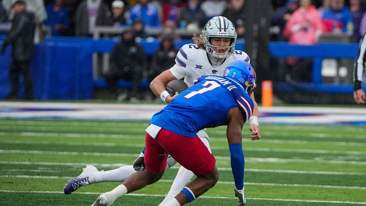 Oct 25, 2025; Lawrence, Kansas, USA; Kansas State Wildcats quarterback Avery Johnson (2) runs the ball as Kansas Jayhawks defensive back DJ Graham II (7) defends during the second half of the game at David Booth Kansas Memorial Stadium. Mandatory Credit: Denny Medley-Imagn Images Oct 25, 2025; Lawrence, Kansas, USA; Kansas State Wildcats quarterback Avery Johnson (2) runs the ball as Kansas Jayhawks defensive back DJ Graham II (7) defends during the second half of the game at David Booth Kansas Memorial Stadium. Mandatory Credit: Denny Medley-Imagn Images