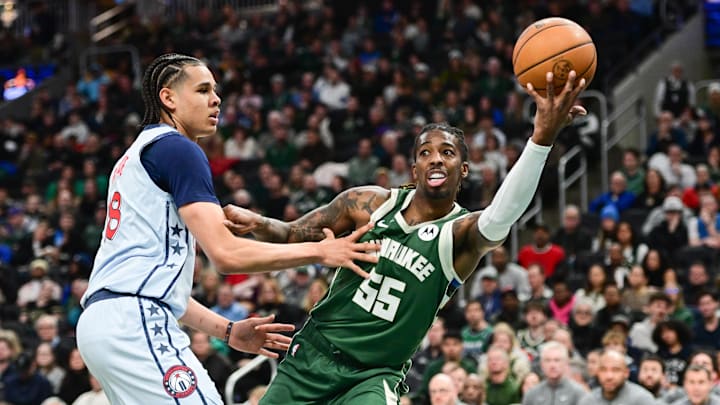 Dec 21, 2024; Milwaukee, Wisconsin, USA; Milwaukee Bucks guard Delon Wright (55) grabs a rebound against Washington Wizards forward Kyshawn George (18) in the second quarter at Fiserv Forum. Mandatory Credit: Benny Sieu-Imagn Images