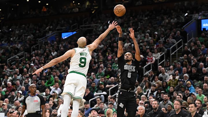 Feb 12, 2025; Boston, Massachusetts, USA; San Antonio Spurs guard Stephon Castle (5) attempts a basket against Boston Celtics guard Derrick White (9) during the fourth quarter at the TD Garden. Mandatory Credit: Brian Fluharty-Imagn Images