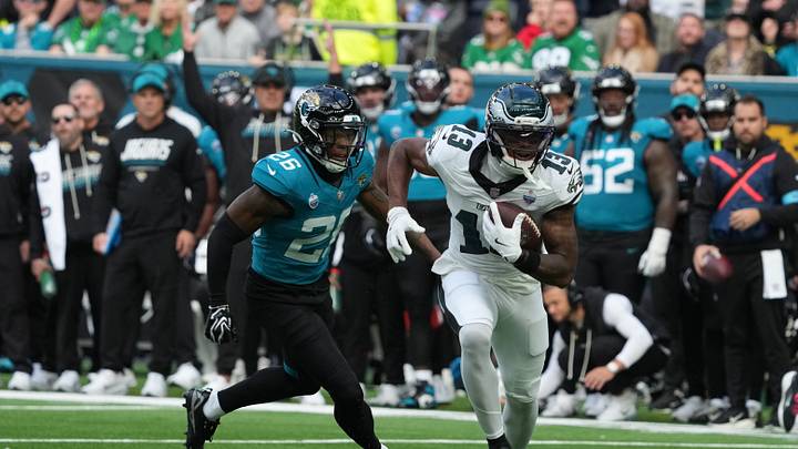 Oct 11, 2026; Tottenham, ENG;  Philadelphia Eagles wide receiver Dontayvion Wicks (13) gains yards after a catch as Jacksonville Jaguars safety Kaevon Merriweather (26) pursues during the first half at Tottenham Hotspur Stadium.  Mandatory Credit: Kirby Lee-Imagn Images