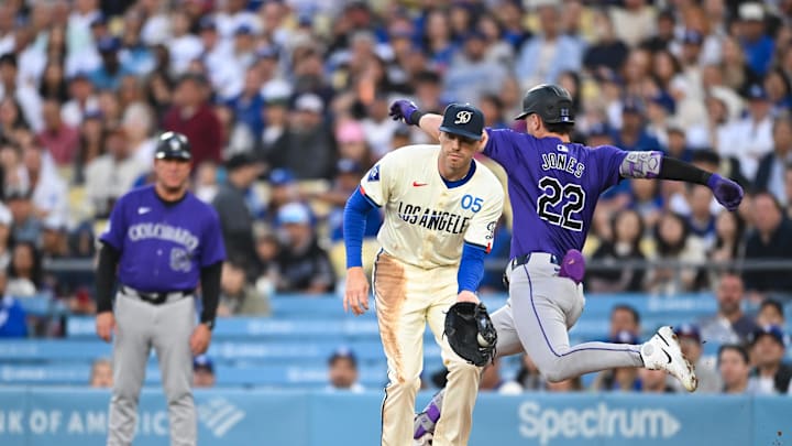 Sep 21, 2024; Los Angeles, California, USA; Colorado Rockies outfielder Nolan Jones (22) singles against Los Angeles Dodgers first baseman Freddie Freeman (5) during the second inning at Dodger Stadium. Mandatory Credit: Jonathan Hui-Imagn Images Sep 21, 2024; Los Angeles, California, USA; Colorado Rockies outfielder Nolan Jones (22) singles against Los Angeles Dodgers first baseman Freddie Freeman (5) during the second inning at Dodger Stadium. Mandatory Credit: Jonathan Hui-Imagn Images