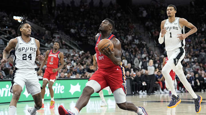 Dec 17, 2023; San Antonio, Texas, USA; New Orleans Pelicans Zion Williamson (1) drives to the basket past San Antonio Spurs guard Devin Vassell (24) and forward Victor Wembanyama (1) during the first half at Frost Bank Center. Mandatory Credit: Scott Wachter-Imagn Images