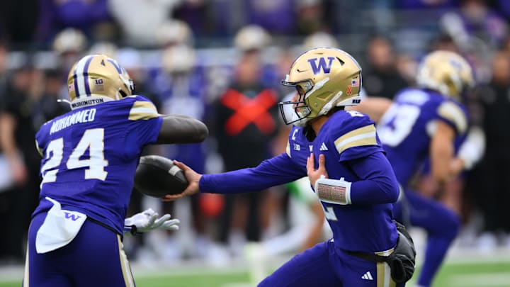 Nov 29, 2025; Seattle, Washington, USA; Washington Huskies quarterback Demond Williams Jr. (2) hands the ball off to running back Adam Mohammed (24) during the first half against the Oregon Ducks at Husky Stadium. Mandatory Credit: Steven Bisig-Imagn Images Nov 29, 2025; Seattle, Washington, USA; Washington Huskies quarterback Demond Williams Jr. (2) hands the ball off to running back Adam Mohammed (24) during the first half against the Oregon Ducks at Husky Stadium. Mandatory Credit: Steven Bisig-Imagn Images