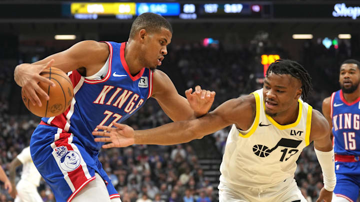 Nov 16, 2024; Sacramento, California, USA; Sacramento Kings center Orlando Robinson (left) dribbles against Utah Jazz guard Isaiah Collier (right) during the first quarter at Golden 1 Center. Mandatory Credit: Darren Yamashita-Imagn Images